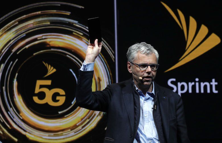 Michel Combes, CEO of Sprint, holds the new LG V50 ThinQ 5G smartphone during its presentation at the Mobile World Congress, in Barcelona, Spain, Sunday, Feb. 24, 2019. The fair started with press conferences on Sunday, before the doors open on Monday, Feb. 25, and runs until Feb. 28. (AP Photo/Manu Fernandez) XAF120 XAF120