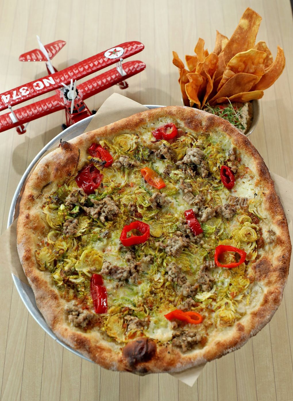 Seaplane in Kenmore offers Smoked Tuna Dip, upper right, and a “Drift” pizza, with sofrito, Brussels sprouts, sausage and peppers. (Greg Gilbert / The Seattle Times)