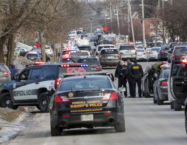 Law enforcement personnel gather near the scene of a shooting at an industrial park in Aurora, Ill., on Friday, Feb. 15, 2019. (Bev Horne/Daily Herald via AP)