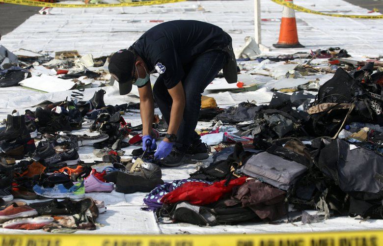 An investigator inspect debris from Lion Air flight JT 610 that crashed into the Java sea on Monday, at Tanjung Priok Port in Jakarta, Indonesia, Friday, Nov. 2, 2018. New details about the crashed aircraft previous flight have cast more doubt on the Indonesian airline’s claim to have fixed technical problems as hundreds of personnel searched the sea a fifth day Friday for victims and the plane’s fuselage. (AP Photo/Binsar Bakkara) 