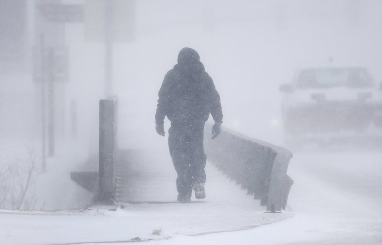 A man crosses Crow Creek during a blizzard on Wednesday, March 13, 2019, in Cheyenne, Wyo.  Heavy snow hit Cheyenne about mid-morning Wednesday and was spreading into Colorado and Nebraska.  (Jacob Byk/The Wyoming Tribune Eagle via AP) WYCHE103 WYCHE103