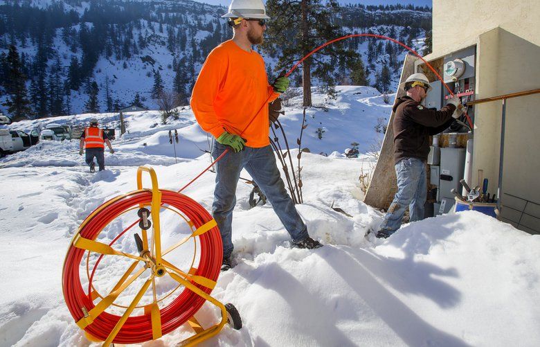 03152019  World photo/Don Seabrook
CJ Christensen, center, helps Joe Linebarier push a fiberglass “rodder” into power conduit at a country home above Malaga, Wash., about 10 miles from Wenatchee Friday, March 15. The Chelan County PUD employees attach fiber optic line to the end of the rodder to get fiber from the distribution line to the house. PUD officials have been instrumental in pushing fiber service to the rural areas of Chelan County.