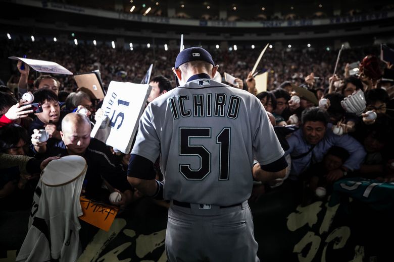 Just before the Mariners take the field, Ichiro stops to sign autographs for fans along the left-field foul line. The Seattle Mariners played the Oakland Athletics on opening day for both teams Wednesday at the Tokyo Dome in Japan. (Dean Rutz / The Seattle Times)