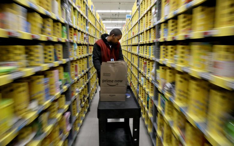 Michael Howard quickly moves his cart through rows of shelving at the  Amazon Prime Now warehouse in Sodo. The 28-year-old is one of scores of workers with a disability employed directly by Amazon through a partnership with Northwest Center. (Alan Berner / The Seattle Times)