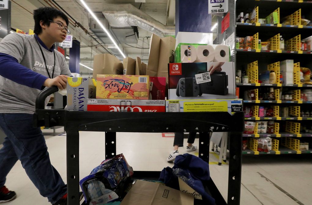 Wilson Yu fills an Amazon Prime order at the warehouse in SoDo. He is one of scores of people who have found work with Amazon through Northwest Center since 2015. (Alan Berner / The Seattle Times)