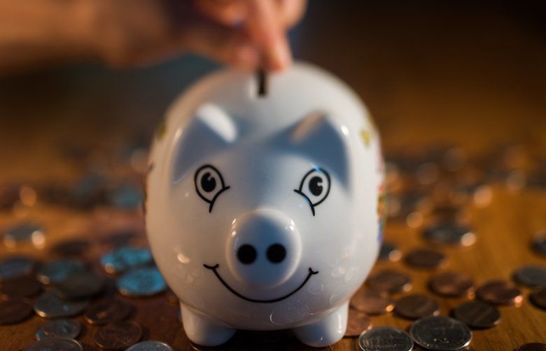 A coin is dropped into a piggy bank.  (Ron Antonelli / Bloomberg)