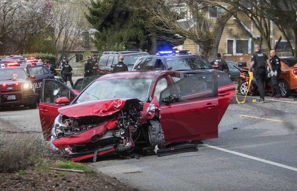 Police work the scene where two cars collided on Sand Point Way Northeast in Seattle on Wednesday after a gunman opened fire. (Steve Ringman / The Seattle Times)