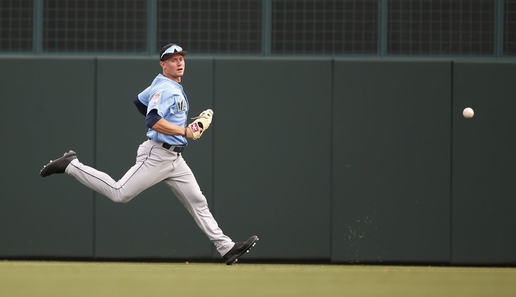 Jarred Kelenic chases a ball March 9 in Phoenix. (Sue Ogrocki / The Associated Press)