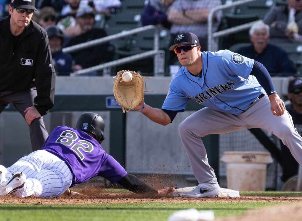 Evan White takes a pickoff attempt Feb. 24 in Scottsdale, Ariz. (Dean Rutz / The Seattle Times)