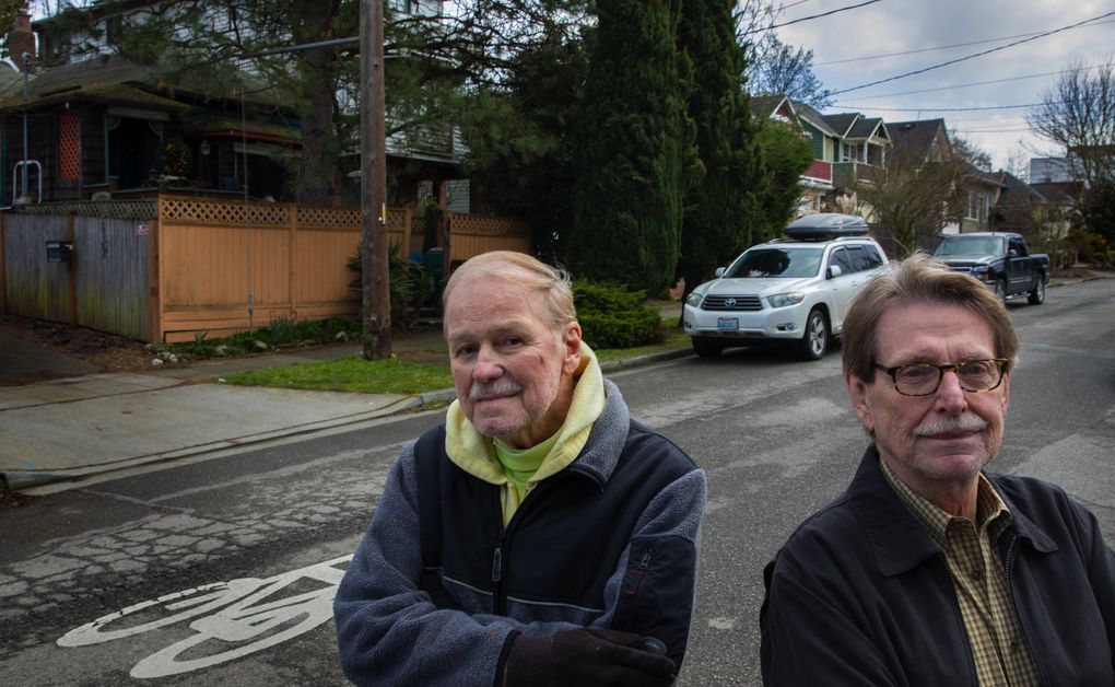 David Dow, left, and his partner, Larry Wood, live in an old timber-frame house, left, that Dow bought in 1973 in the Youngstown neighborhood of West Seattle. Proposed light-rail routes would carve through their block. All of the buildings in the photo, and many more, would be torn down. (Ellen M. Banner / The Seattle Times)