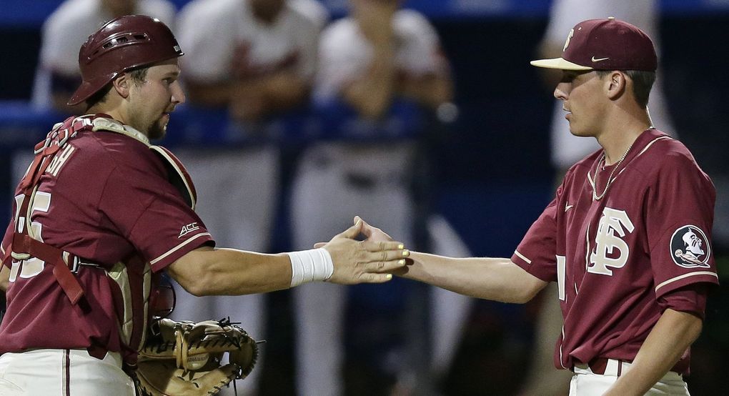 Catcher Cal Raleigh congratulates Florida State pitcher C.J. Van Eyk in 2018. (Gerry Broome / The Associated Press)