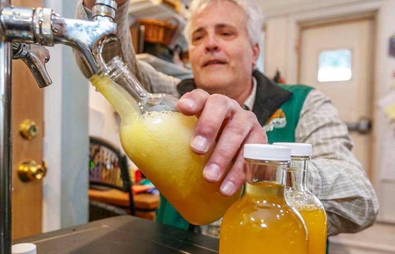 Weavers Way Co-op store manager Rick Spalek fills 16 ounce bottles with GT'S Cannabliss kombucha , which contains CBD, from the tap on the second floor of the Mount Airy store. (Michael Bryant/The Philadelphia Inquirer/TNS)