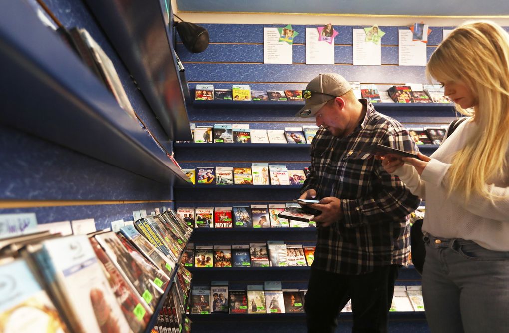 Preston Cronce and Sarah Stiltner browse Reckless Video last year. Cronce said the couple streams videos as well, but having grown up in the Blockbuster era, he loves the store experience. (Ken Lambert / The Seattle Times, 2018)
