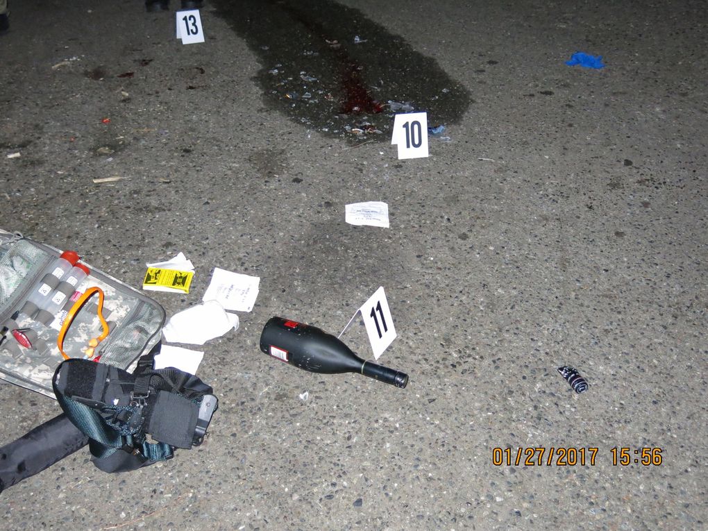 Chance Dunlap-Gittens was reportedly carrying three bottles of liquor when he was shot by officers. A bottle of cognac, still intact, lies where the 17-year-old fell. Broken glass from a second bottle is visible at top. (King County Sheriff’s Office)