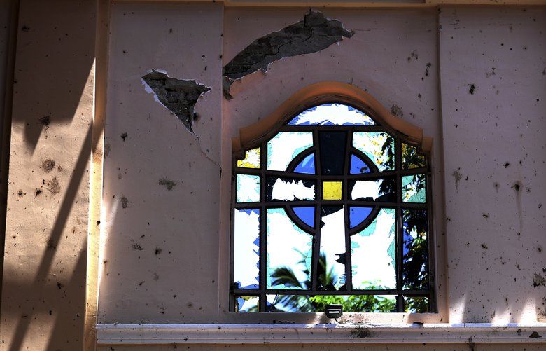 In this Thursday, April 25, 2019 photo, a stained-glass window stands broken at Sebastian’s Church, where a suicide bomber blew himself up on Easter Sunday in Negombo, north of Colombo, Sri Lanka. Nearly a week later, the smell of death is everywhere, though the bodies are long gone. Yet somehow, thereâ€™s a beauty to St. Sebastianâ€™s, a neighborhood church in a Catholic enclave north of Sri Lankaâ€™s capital. You can see the beauty in the broken stained-glass windows. Itâ€™s there as the sun shines through the roofâ€™s gaping holes. Itâ€™s there in the little statues that refused to fall over, and despite the swarms of police and soldiers who seem to be everywhere now in the streets of the seaside town of Negombo. (AP Photo/Manish Swarup) XMS109 XMS109