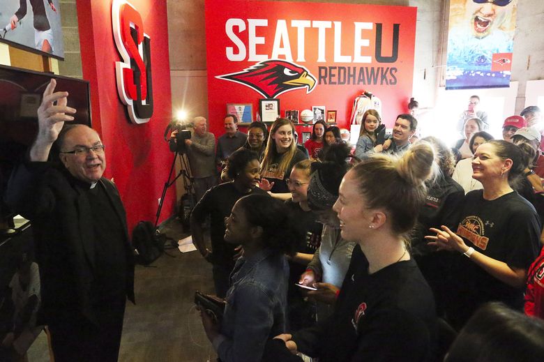 Father Stephen Sundborg, president of Seattle University, left, speaks to media in 2018 after the SU women’s basketball team learned they would play in the NCAA tournament for the first time. (Ken Lambert / The Seattle Times)