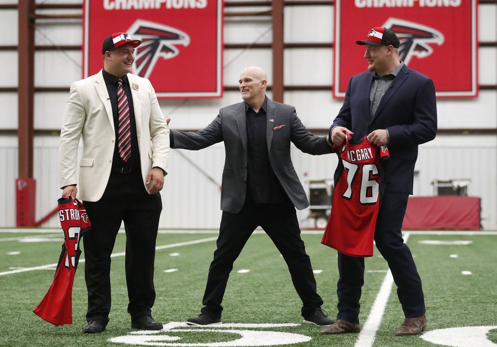 Atlanta Falcons coach Dan Quinn, center, talks with Kaleb McGary, right, from Washington and Chris Lindstrom, left, of Boston College the day after selecting them in the first round of the NFL draft. (John Bazemore / The Associated Press)
