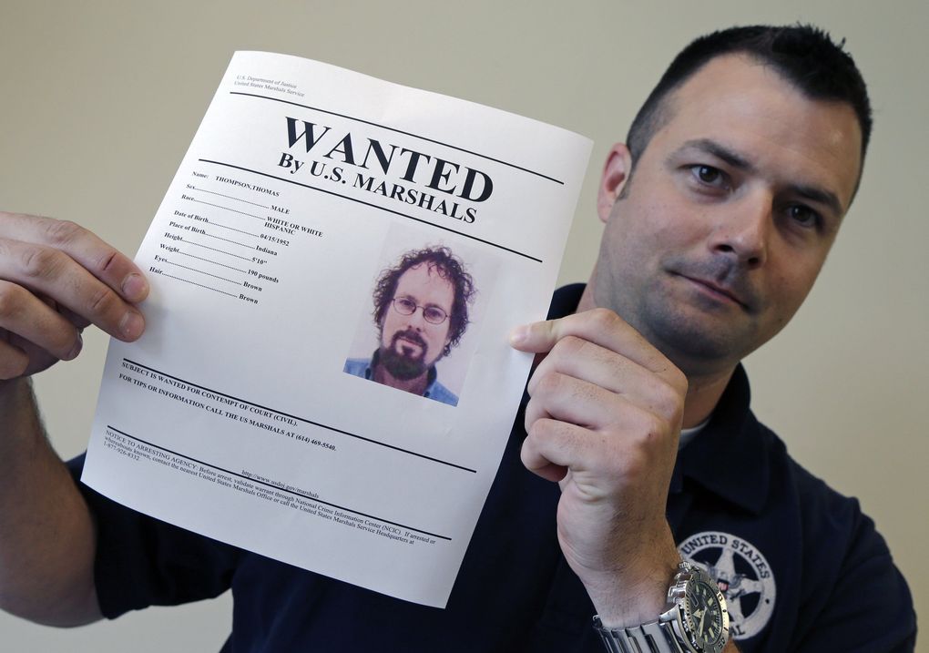 U.S. Marshal Brad Fleming displays a wanted poster for fugitive treasure hunter Tommy Thompson in Columbus, Ohio. Thompson led a group that recovered millions of dollars worth of sunken treasure only to end up involved in court cases. Thompson was later found and is in prison, not saying where $50 million and gold coins are being hidden.
(Associated Press)