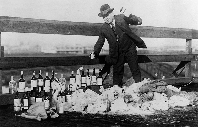 King County sheriff Matt Starwich destroying confiscated bottles of liquor. (from the book “Seattle Prohibition: Bootleggers, Rumrunners & Graft in the Queen City by Brad Holden (Arcadia Publishing 2019).”