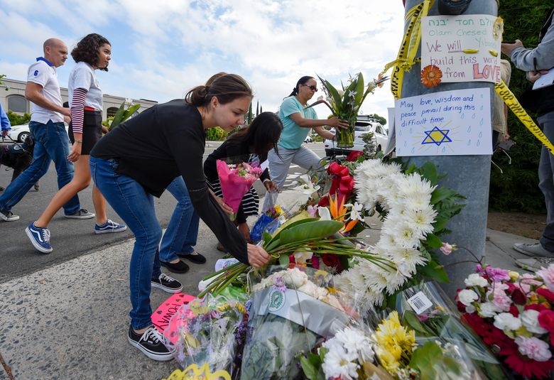 A group of Poway residents bring flowers and cards to a memorial outside of the Chabad of Poway synagogue, Sunday, April 28, 2019, in Poway, Calif. A man opened fire Saturday inside the synagogue near San Diego as worshippers celebrated the last day of a major Jewish holiday. (AP Photo/Denis Poroy) (AP Photo/Denis Poroy)