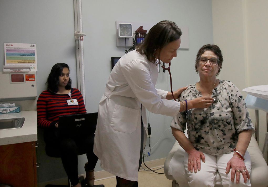 Dr. Megan Mahoney, center, examines patient Consuelo Castaneda, right, as medical scribe Anu Tirapasur documents the visit at the Stanford Family Medicine office in Stanford, Calif. (Jeff Chiu / The Associated Press, file)