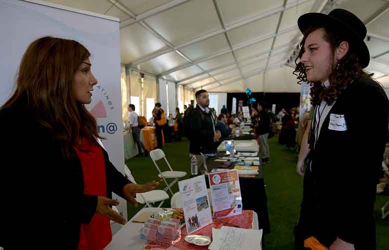 Ryan Blake, 22, right, speaks with an employer representative at the St. John’s Well Child and Family Center’s job fair for the transgender community at Los Angeles Trade-Tech College on March 13. (Francine Orr / Los Angeles Times via TNS)