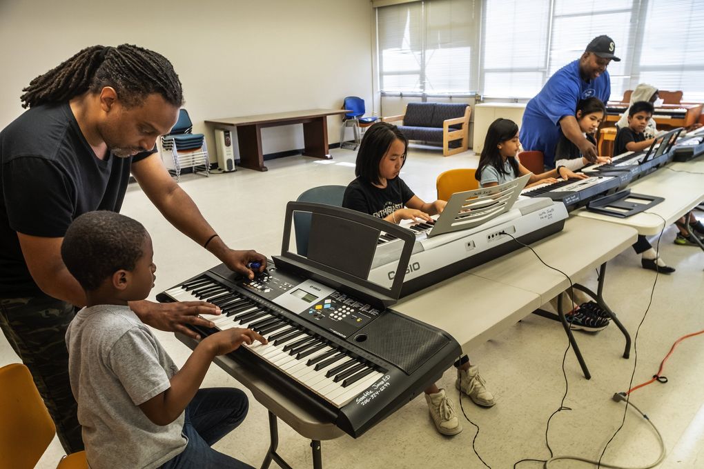 Darrius Willrich teaches keyboards to Khalil Jeffries at JazzED. Sherrell Mitchell, standing, is another teacher/musician with the program. (Dean Rutz / The Seattle Times)