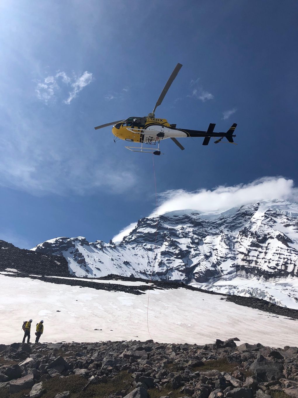 Mount Rainier National Park’s rescue helicopter on Thursday delivers a patient, using the “short haul” technique, from an accident site at 10,400 feet on Liberty Ridge to a staging area at 7,000 feet on Curtis Ridge, on the north side of Mount Rainier. (National Park Service)
