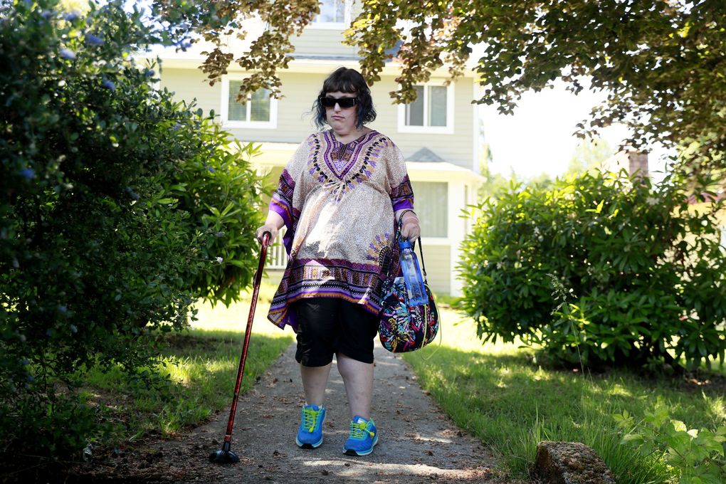Christine Miles walks to board Metro’s Access paratransit bus in Tukwila. The bus takes her to her job in Seattle. (Erika Schultz / The Seattle Times)