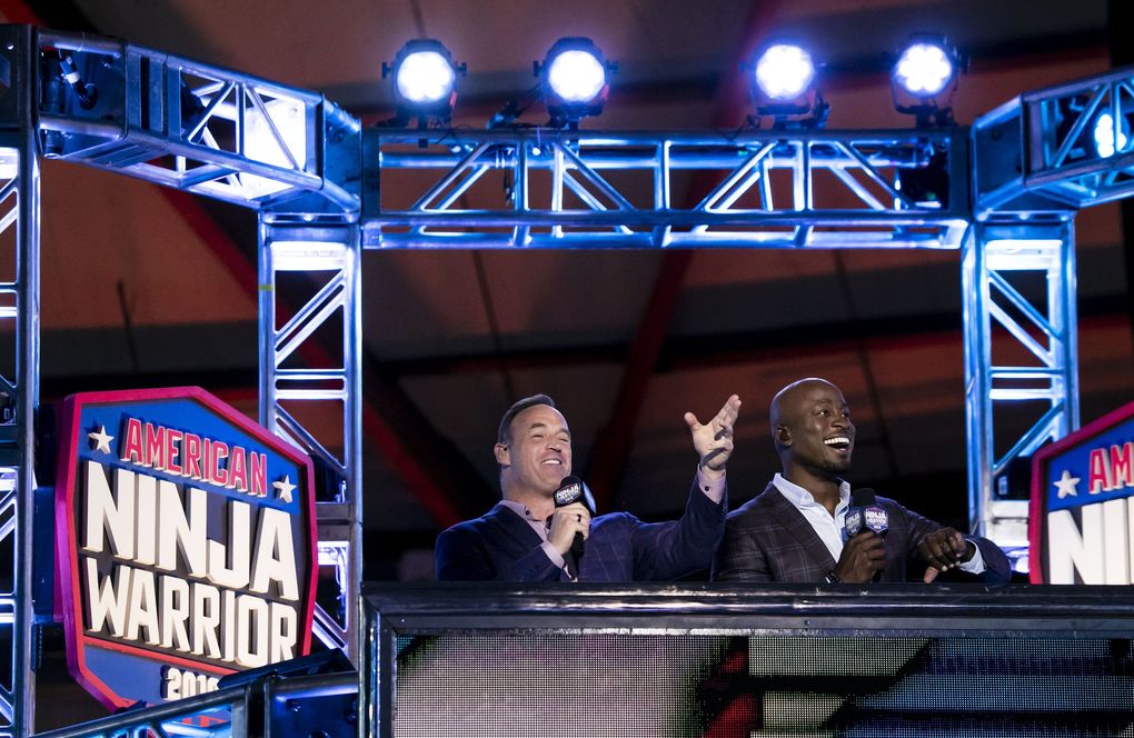 “American Ninja Warrior” hosts Matt Iseman, left, and Akbar Gbajabiamila narrate the action with energetic banter from the play-by-play box next to the Warped Wall. (Erika Schultz / The Seattle Times)