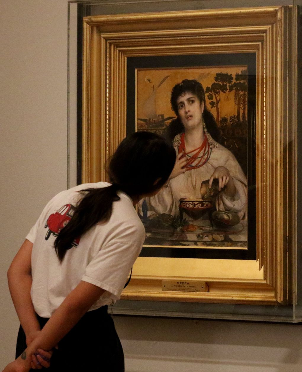 Mariko Yoshino, an intern at Seattle Art Museum, gets a close-up look at “Medea,” 1866-68, Frederick Sandys’ oil on composite wood panel with gold leaf. It’s part of SAM’s “Victorian Radicals” exhibition. (Alan Berner / The Seattle Times)