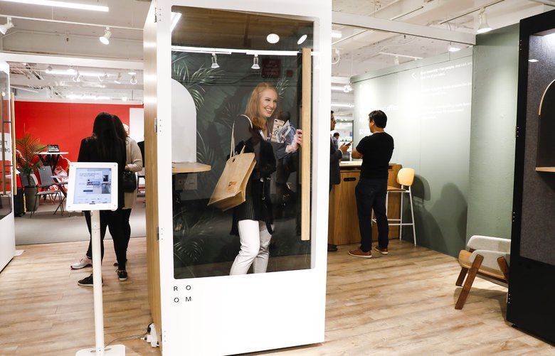 Gabriella Massey, a junior interior designer with Bailey Edward, takes a peek at a phone booth by ROOM on the 7th floor at NeoCon being held at the Merchandise Mart on Monday, June 10, 2019. A new trend in offices are phone booth-like spaces that create a sense of privacy for employees as opposed to the open floor office trend that has been popular. (Jose M. Osorio/Chicago Tribune/TNS) 