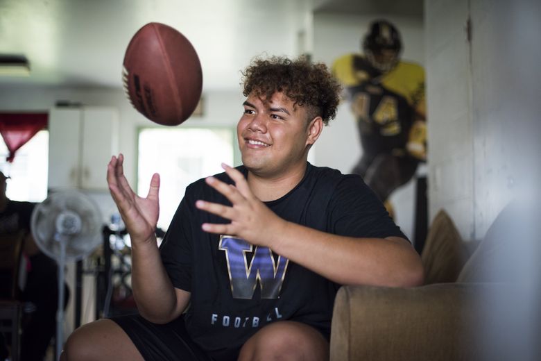Faatui Tuitele, a Saint Louis High School football player and top recruit in University of Washington’s 2019 class, tosses a football at the Mayor Wright Housing project where he grew up. (Elyse Butler / Special to The Seattle Times)