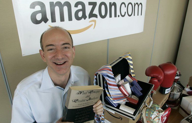 ** ADVANCE FOR TUESDAY JULY 5 ** Amazon.com founder and CEO Jeff Bezos holds a copy of “Fluid Concepts and Creative Analogies” by Douglas Hofstadter — the first book sold on-line by Amazon.com — as he stands Friday, June 17, 2005 at the company’s headquarters in Seattle next to a table that shows only a small sampling of non-book items currently available on Amazon.com including boxing gloves, a heart defibrillator, kitchen and electronics equipment, and clothing items. Amazon.com launched on the web ten years ago on July 16th, 1995. (AP Photo/Ted S. Warren)

WATW401