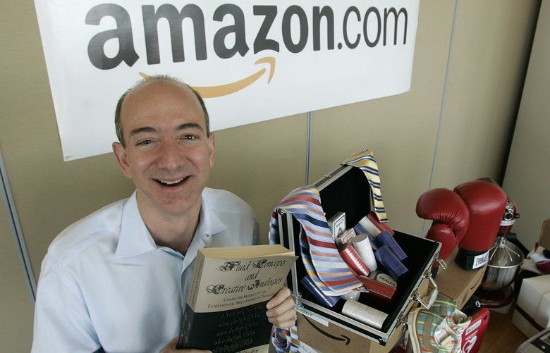 ** ADVANCE FOR TUESDAY JULY 5 ** Amazon.com founder and CEO Jeff Bezos holds a copy of “Fluid Concepts and Creative Analogies” by Douglas Hofstadter — the first book sold on-line by Amazon.com — as he stands Friday, June 17, 2005 at the company’s headquarters in Seattle next to a table that shows only a small sampling of non-book items currently available on Amazon.com including boxing gloves, a heart defibrillator, kitchen and electronics equipment, and clothing items. Amazon.com launched on the web ten years ago on July 16th, 1995. (AP Photo/Ted S. Warren)
WATW401