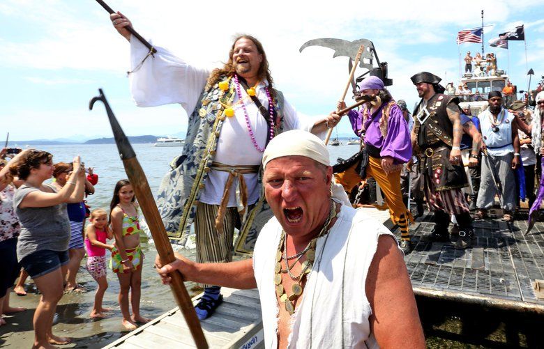 The Seafair Pirates arrived Saturday afternoon at Alki Beach to a cheering crowd of thousands. 
Seafair Pirate Marvin Davis, center, and Keldy Ney, left, step off the pirates barge into a the crowd at the Alki Beach shoreline.