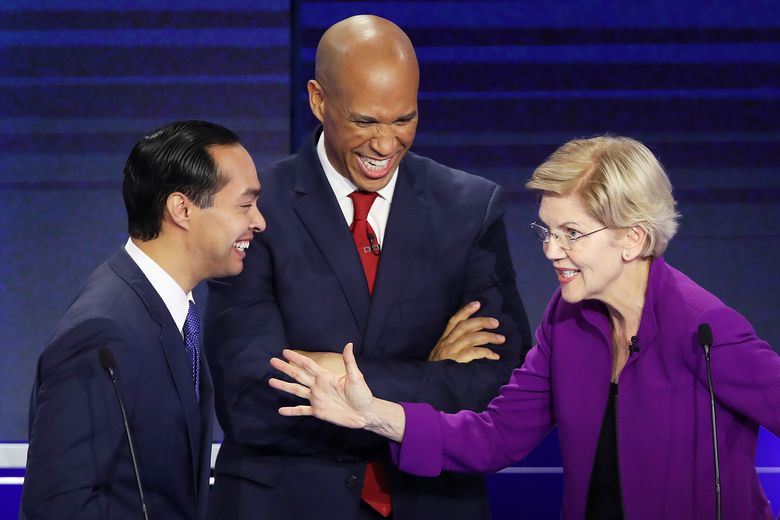 From left, former housing secretary Julian Castro, Sen. Cory Booker (D-N.J.) and Sen. Elizabeth Warren (D-Mass.) react during the first night of the Democratic presidential debate on Wednesday, June 26, 2019, in Miami. A field of 20 Democratic presidential candidates was split into two groups of 10 for the first debate of the 2020 election, taking place over two nights at Knight Concert Hall of the Adrienne Arsht Center for the Performing Arts of Miami-Dade County, hosted by NBC News, MSNBC, and Telemundo. (Joe Raedle/Getty Images/TNS) **FOR USE WITH THIS STORY ONLY**