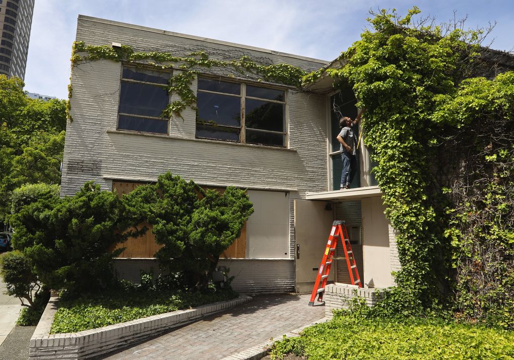 Greg Lundgren takes a tape measure to the windows over the main entrance of this former medical building that he is renovating into Museum of Museums (MoM), which will house two gallery spaces, rotating exhibitions from private collectors and more. (Ken Lambert / The Seattle Times)