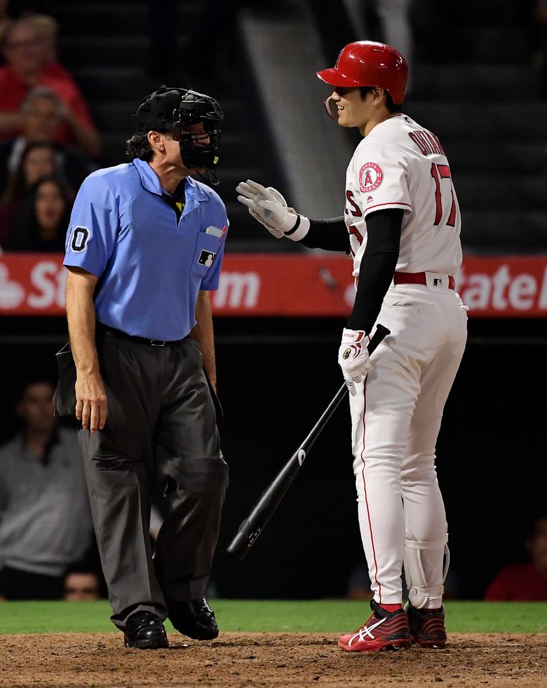 Los Angeles Angels' Kole Calhoun, center, is helped off the field