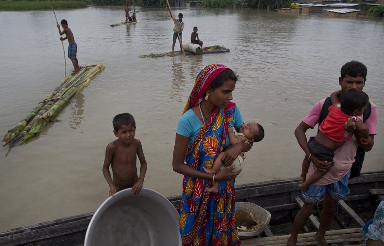 Flood affected villagers with their children travel on a boat in Katahguri village along river Brahmaputra, east of Gauhati, India, Sunday, July 14, 2019. Officials in northeastern India said more than a dozen people were killed and over a million affected by flooding. Rain-triggered floods, mudslides and lightning have left a trail of destruction in other parts of South Asia. (AP Photo/Anupam Nath) AXN115 AXN115