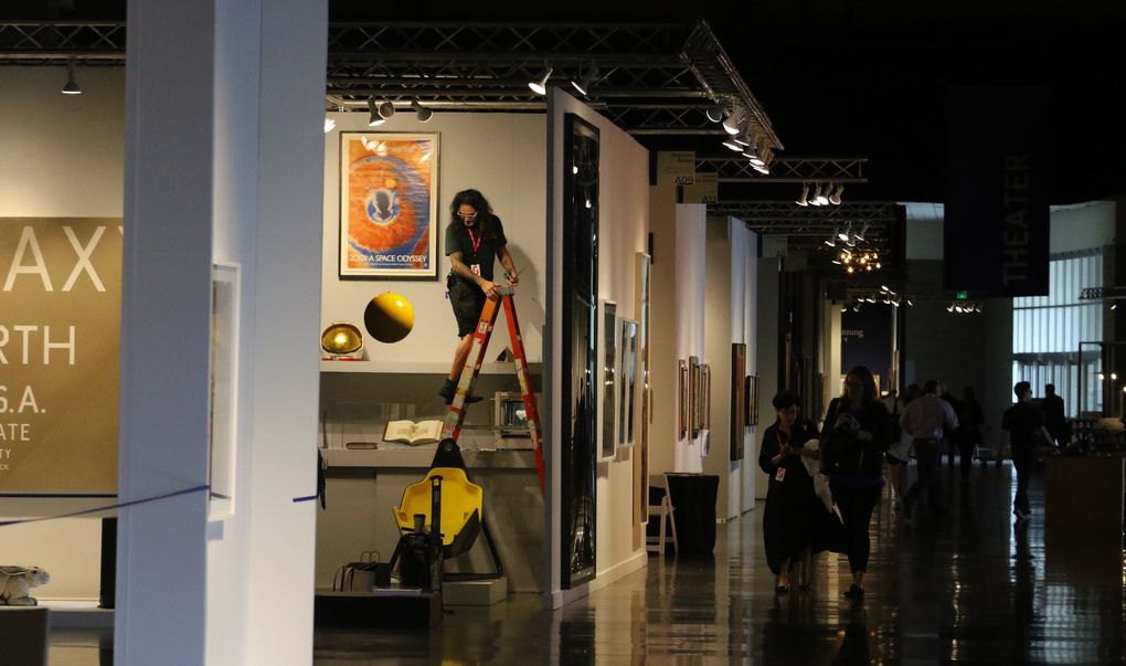 Adjustments are made at an exhibitor’s space at the 2018 Seattle Art Fair at CenturyLink Event Center. Last year, about 22,500 people attended, and about the same number is expected this year. (Alan Berner / The Seattle Times, 2018)