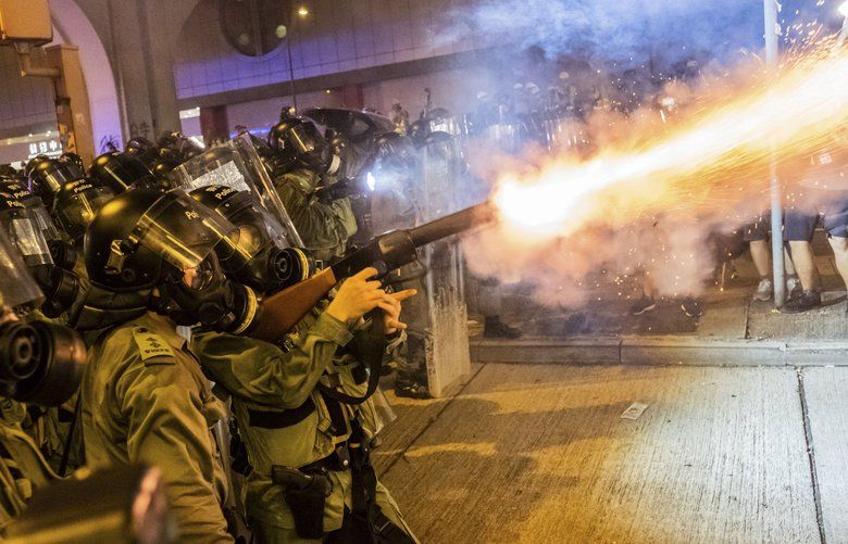 A police officer fires tear gas during clashes with protesters in Hong Kong, July 21, 2019. Tens of thousands of demonstrators marched across Hong Kong’s main island on Sunday to protest the city’s embattled government, occupying major thoroughfares in defiance of police orders and vandalizing the Chinese government’s liaison office in the city. (Lam Yik Fei/The New York Times) XNYT117 XNYT117