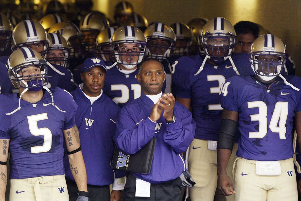 Tyrone Willingham leads the Huskies out of the tunnel in uniforms from an era of Husky football many fans would like to forget. (Dean Rutz / The Seattle Times)