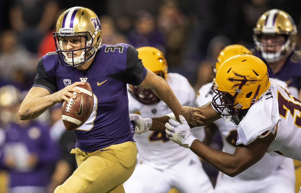 Jake Browning escapes defenders in UW’s former Nike threads. (Dean Rutz / The Seattle Times)