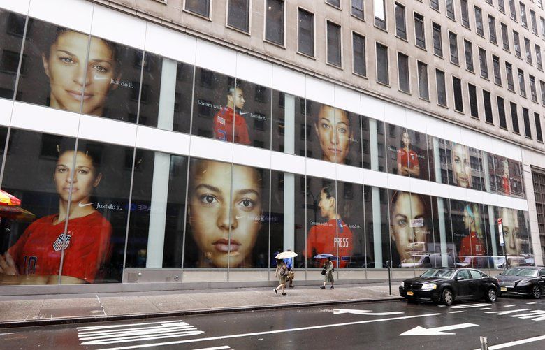 Portraits of the USA women’s soccer team members are visible in the windows of a building on Fifth Avenue, in New York, Thursday, June 13, 2019. Women’s soccer engages the U.S. every four years, then disappears for most fans like Brigadoon. In the wake of the Americans’ record-setting fourth World Cup title Sunday, July 7, 2019, the hard part remains ahead: the weekly work of boosting the National Women’s Soccer League. (AP Photo/Richard Drew) NYRD201 NYRD201