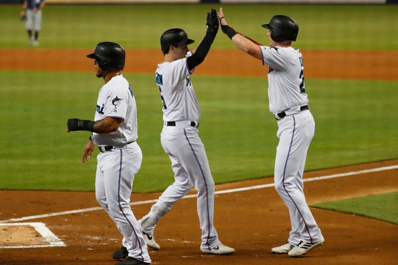 San Diego Padres' Garrett Cooper, right, celebrates with third