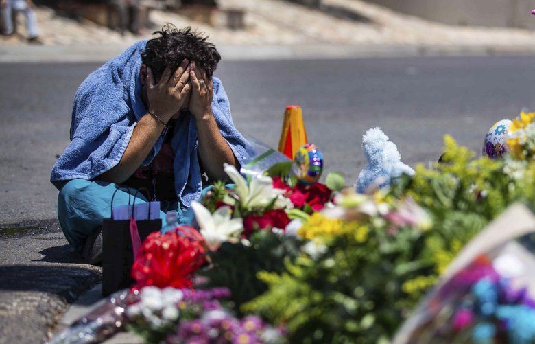 A man puts his head in his hands as he cries Sunday, Aug. 4, 2019, in El Paso, Texas,at the place where locals came to honor the memory of the victims of the mass shooting occurred in Walmart on Saturday, Aug. 3, 2019. (Lola Gomez/Austin American-Statesman via AP) 