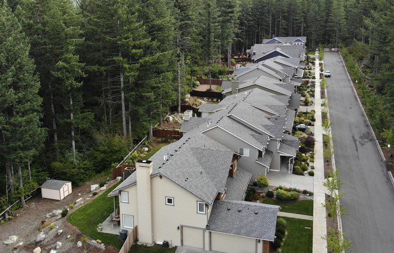 In this photo taken July 24, 2019, a block of houses is surrounded on three sides by a forest in the Cascade foothills of North Bend, Wash. Experts say global warming is changing the region’s seasons, bringing higher temperatures, lower humidity and longer stretches of drought. And that means wildfire risks in coming years will extend into areas that haven’t experienced major burns in residents’ lifetimes. (AP Photo/Elaine Thompson) WAET206 WAET206