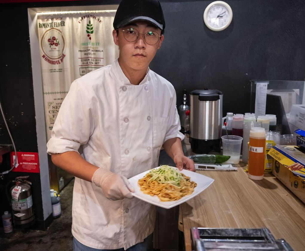 Northern Dumpling House owner Evan Wang prepares a spicy noodle dish at the Kirkland restaurant. Wang runs the place with his wife. (Dean Rutz / The Seattle Times)