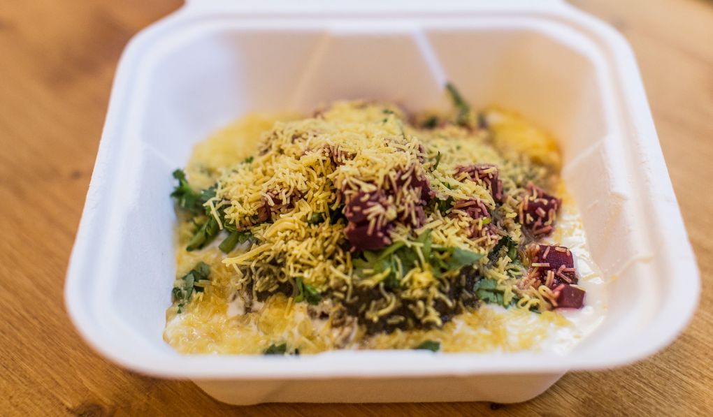 Spice Waala’s “iconic Indian snack” aloo tikki chaat brings sweet, savory, salty, creamy and crunchy all to one plate — or one precious cardboard clamshell to-go container, in this case. (Rebekah Welch / The Seattle Times)